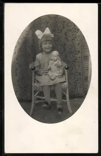 AK Kind mit Schleife im Haar und einer Puppe auf dem Schoss