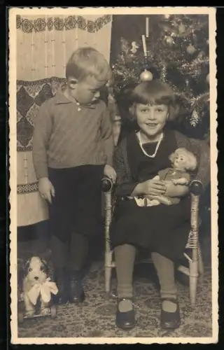 Foto-AK Kinder an einem Weihnachtsbaum mit Puppe auf dem Schoss und Hund auf Rollen