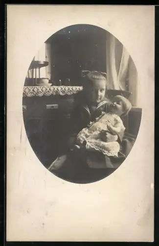 Foto-AK Kleines Kind mit einer Puppe auf dem Schoss