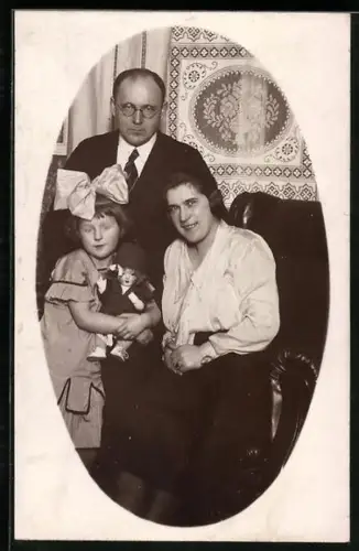 Foto-AK Familienportrait mit Kind, das eine Puppe im Arm hält