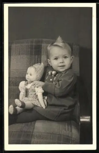 AK Kleinkind sitzt mit einer Puppe auf dem Schoss auf einem Stuhl
