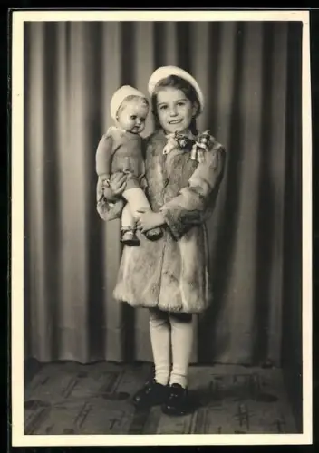 Foto-AK Mädchen hält stolz eine Puppe in dem Armen