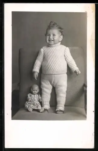Foto-AK Kleinkind steht neben einer Puppe auf einem Sessel 1944