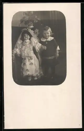 Foto-AK Kleinkind steht neben einer Puppe