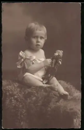 Foto-AK Kleinkind sitzt mit einer Puppe auf einem Fell