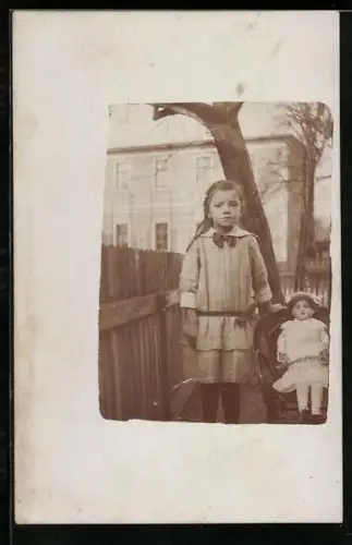Foto-AK Mädchen mit ihrer Puppe auf einem Stuhl im Garten