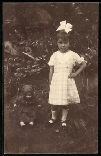 Foto-AK Mädchen in kariertem Kleid mit einer Puppe im Garten