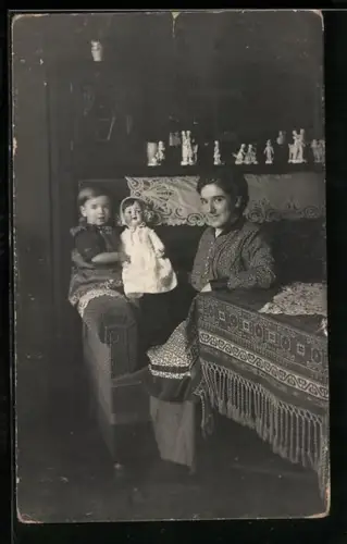 Foto-AK Mutter und Kind sitzten mit einer Puppe auf dem Sofa