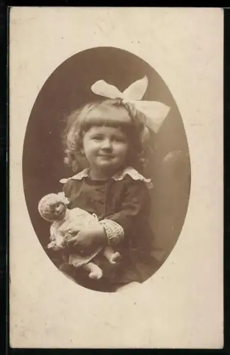Foto-AK Lächelndes Mädchen mit einer Puppe in den Armen