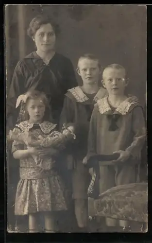 Foto-AK Familie mit zwei Jungen und einem Mädchen mit Puppe