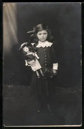 Foto-AK Mädchen hält eine Puppe im Arm
