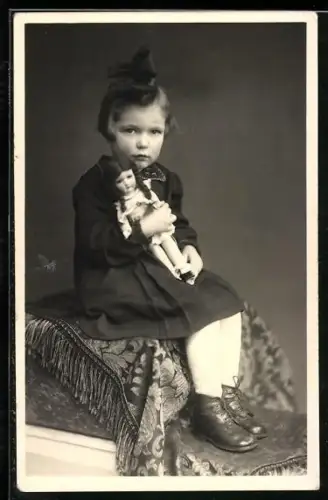 Foto-AK Sitzendes Mädchen hält eine Puppe in den Armen 1944