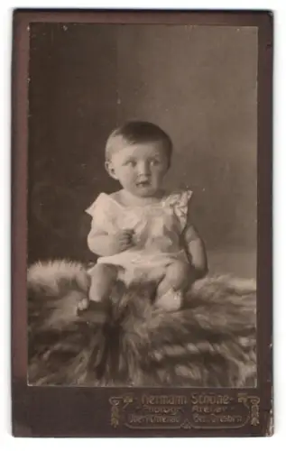 Fotografie Hermann Schöne, Oberlichtenau, Kleinkind auf einem Fell
