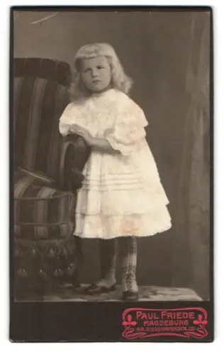 Fotografie Paul Friede, Magdeburg, Gr. Diesdorferstr. 32, Mädchen in weissem Kleid neben Stuhl