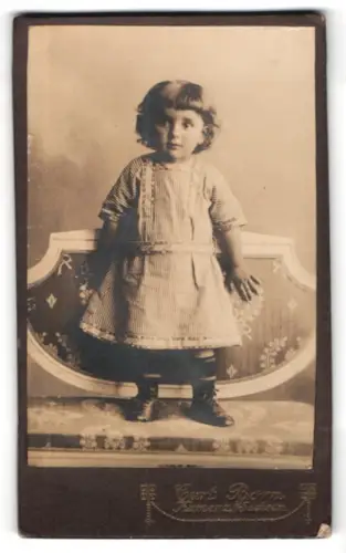 Fotografie Carl Born, Kamenz i. Sachsen, Kind auf einem dekorativen Stuhl