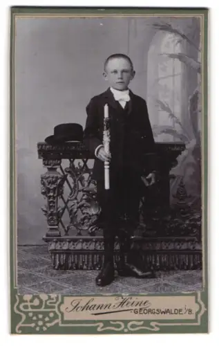 Fotografie Johann Heine, Georgswalde, Junge mit Kerze im feierlichen Anzug