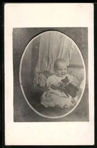 Foto-AK Kleinkind mit Teddy in den Händen