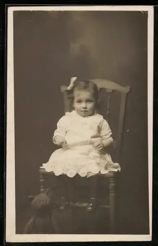 Foto-AK Kleinkind auf einem Stuhl mit Teddy