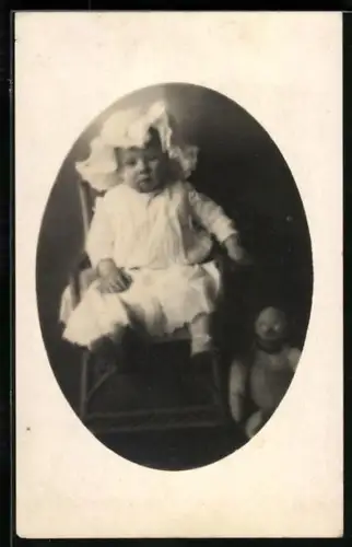 Foto-AK Kleinkind auf einem Stuhl mit einem Teddy neben sich