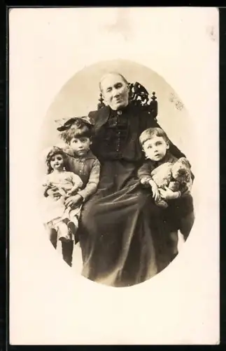 Foto-AK Ältere Dame mit zwei Kindern mit Teddy und Puppe