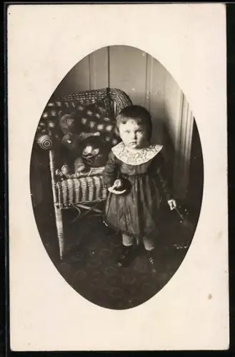 Foto-AK Kleinkind mit Ball vor einem Stuhl mit Teddy