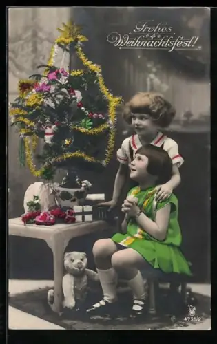 AK Zwei Kinder mit einem Teddy neben einem Weihnachtsbaum