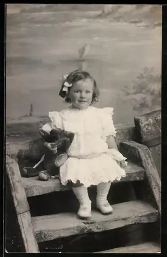 Foto-AK Kleinkind sitzt mit einem Teddy auf einer Treppe 1912