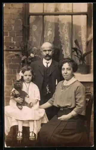 Foto-AK Familienbild mit Teddy vor einem Haus