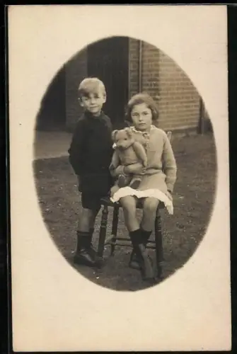 Foto-AK Zwei Kinder mit Teddy vor einem Haus
