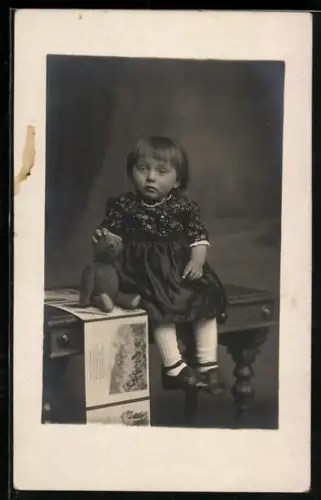 Foto-AK Kleinkind sitzt mit einem Teddy auf einem Tisch