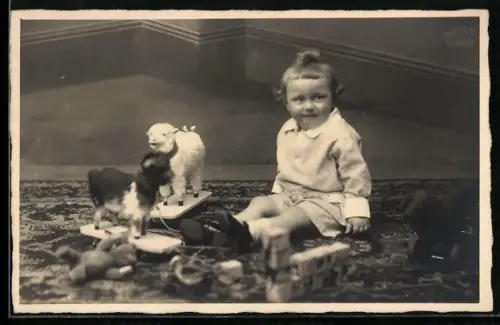 AK Kleinkind sitzt mit Teddy und anderen Spielzeugen auf einem Teppich