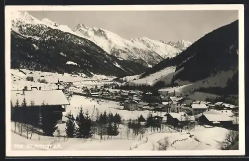AK St. Anton a. A., Winterpanorama mit verschneitem Ort und Bergkulisse