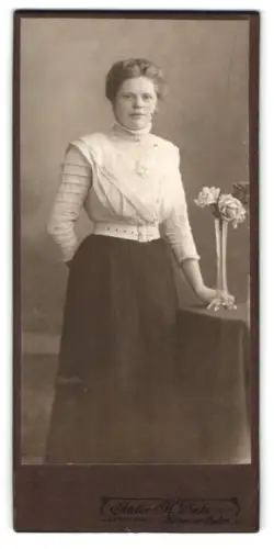 Fotografie H. Deike, Hannover-Linden, Deisterstrasse 7, Frau stehend neben Tisch mit Blumen