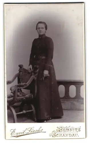 Fotografie Emil Lieske, Schandau, Kirchgasse 27, Stehende Dame neben kunstvollem Stuhl