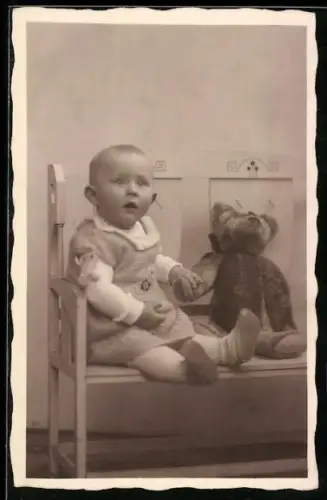 Foto-AK Kleinkind sitzt mit einem Teddy auf der Bank