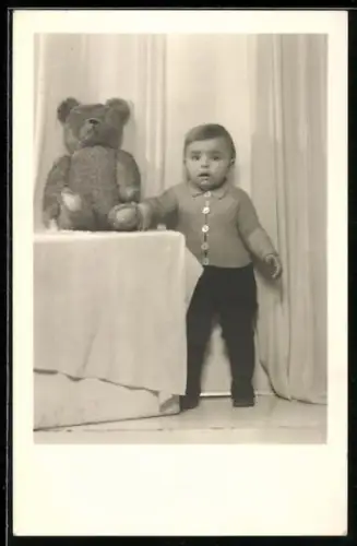 Foto-AK Kleines Kind steht neben einem Teddy