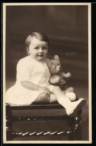 Foto-AK Kleinkind mit einem Teddy in den Armen