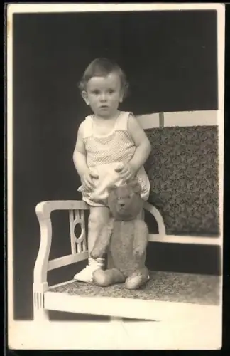Foto-AK Kleinkind mit Teddy auf einer Bank