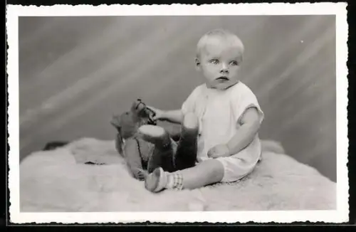 Foto-AK Kleinkind sitzt mit einem Teddy auf einer Decke