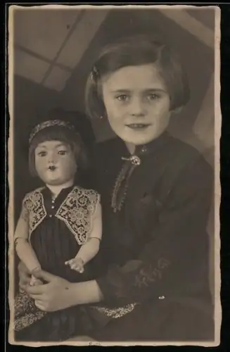 Foto-AK Mädchen und Puppe mit Ponyfrisur und Faltenkleid