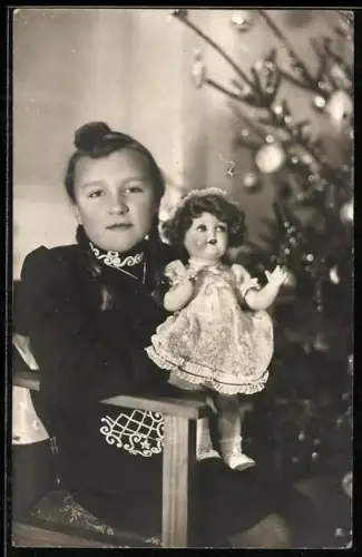 Foto-AK Mädchen mit Dutt und Puppe vor dem Weihnachtsbaum