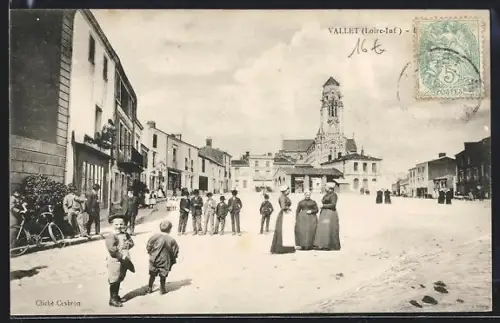 AK Vallet /Loire-Inf., Scène animée sur la place avec église en arrière-plan