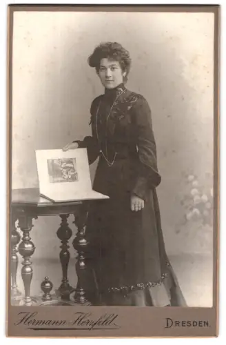 Fotografie Hermann Herzfeld, Dresden, Altmarkt, Elegante Dame mit Buch an Tisch