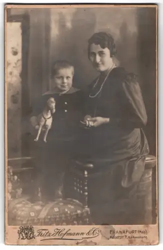 Fotografie Fritz Hofmann & Co., Frankfurt a. Main, Kaiserstr. 7, Mutter mit Kind und Spielzeugpferd