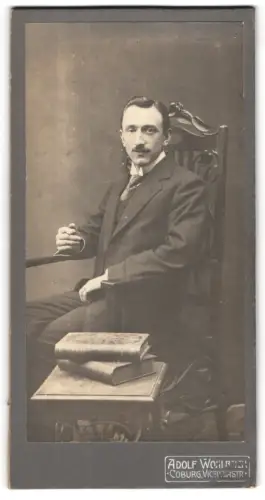 Fotografie Adolf Wohlbach, Coburg, Victoriastr., Porträt eines sitzenden Mannes mit Buch