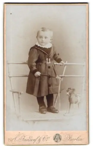 Fotografie A. Jandorf & Co., Berlin, Grosse Frankfurterstr. 113, Kleinkind in eleganter Kleidung mit Spielzeug