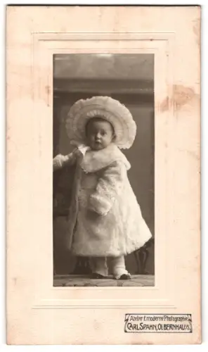 Fotografie Carl Spahn, Olbernhau i. S., Kleinkind im eleganten Mantel