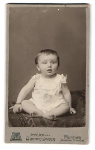 Fotografie Atelier Oberpollinger, München, Neuhauser Strasse 44, Sitzendes Kleinkind mit Perlenkette