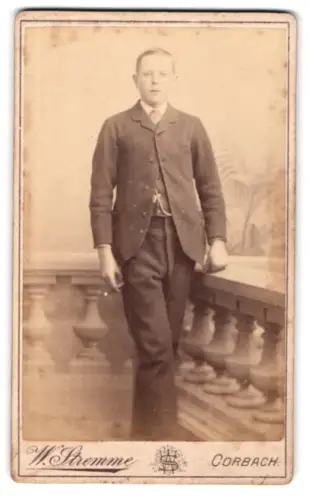 Fotografie W. Stremme, Corbach, Stehender junger Mann an einer Ballustrade