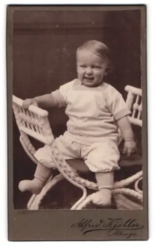 Fotografie Alfred Kjöller, Allinge, Kleinkind auf einem Korbstuhl